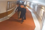 Policial conduz manifestante com toga preta de ministro do STF, durante atos de 8 de janeiro