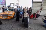 Palestinos com passaportes estrangeiros no Portão Fronteiriço de Rafah esperam para cruzar para o Egito enquanto os ataques aéreos israelenses continuam