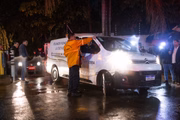 Fiscais da Defesa Civil são vistos na frente de um carro funerário no local de um acidente de avião em Vinhedo, cidade localizada a aproximadamente 100 km de São Paulo
