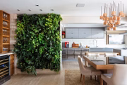 Próximo à área gourmet do apartamento integrado, o jardim vertical contribui com o décor