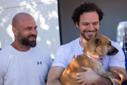 O deputado Federal Fred Costa (PRD – MG) segurando uma cachorrinha no colo e ao lado de um adotante