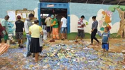 Garis limparam sujeira de santinhos, em frente à Escola 66, no Sol Nascente