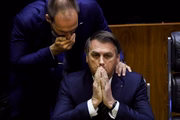 Bolsonaro, em solenidade na Câmara dos Deputados, conversa com o filho Eduardo
