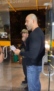 Outro agente entrega uma máscara para o parlamentar