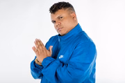 MC Delux posa de moletom azul para fotos de divulgação