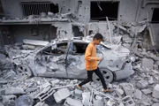 Na cidade de Deir al Balah, criança anda entre os escombros de prédios destruídos por bombardeios de Israel