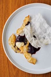 Os carros-chefes do menu chegam com um prato composto por nhoque de batata roxa com molho de açaí e creme de queijo e o lardo, gordura das costas do porco maturada por um ano