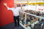 O cartunista no interior de seu estúdio com a equipe de criação ao fundo