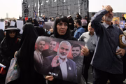 Mulher carrega foto de Ismail Haniyeh durante funeral do líder