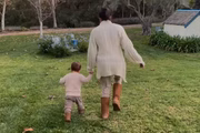 Meghan caminha com o menino pelo jardim 