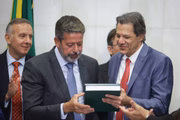 Haddad com o texto da reforma tributária, ao lado de Lira