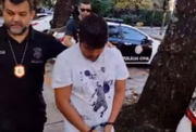 Jonathan é conduzido por policial civil, logo após ser preso no Rio de Janeiro 
