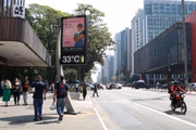 Pedestres caminham sob o sol na Avenida Paulista