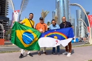 Torcedor pernambucano com a camisa da seleção brasileira posa com jornalistas conterrâneos e a bandeira do estado