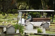Sepultadores usam máscaras para transitar no cemitério