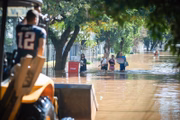 Pessoas são vistas com águas na cintura após a enchente do Rio Guaíba inundarem as ruas da cidade de Porto Alegre no Rio Grande do Sul