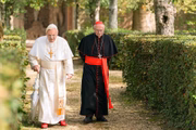 <b>Dois Papas:</B> o cardeal argentino Jorge Bergoglio está decidido a pedir sua aposentadoria, devido a divergências sobre a forma como o papa Bento XVI tem conduzido a Igreja. Com a passagem já comprada para Roma, ele é surpreendido com o convite do próprio papa para visitá-lo. Ao chegar, eles iniciam uma longa conversa na qual debatem não só os rumos do catolicismo, mas também afeições e peculiaridades da personalidade de cada um