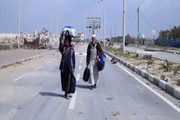 Abdullah e Aisha Qarmout caminhando pela rua Al Rachid no caminho do norte de Gaza para o sul