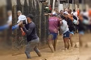 Pessoas fazem fila humana para carregar crianças após chuvas em SP