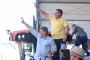 Bolsonaro e Tarcísio acenam para apoiadores em cima de trator, na Agrishow