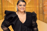 Preta Gil posa sorridente de look preto