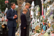 Ao lado do pai Charles, os irmãos leem as homenagens deixadas para a princesa Diana. A mãe dos príncipes morreu em um acidente de carro 