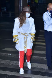Ela aparece vestida com roupão, boné e máscara