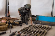 Um soldado israelense exibe equipamento militar e munições que militantes do Hamas e palestinos usaram no momento do ataque na fronteira sul de Israel com a Faixa de Gaza em 20 de outubro de 2023