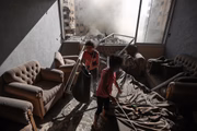 Crianças são vistas em uma casa destruída após ataques israelenses na Cidade de Gaza