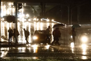 Pedestres atravessam Eixo Monumental na chuva 