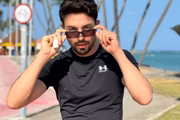 Rico Melquiades posa de look preto e óculos escuros