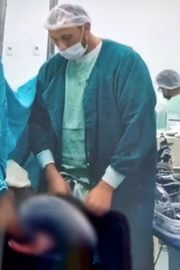 Médico aparece com a mão nas partes íntimas durante cirurgia