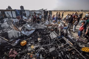 Palestinos observam a destruição causada pelos ataques do exército israelense às tendas de deslocados que vivem perto dos armazéns da Agência das Nações Unidas de Assistência e Obras para Refugiados Palestinos (UNRWA) em Rafah