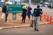 Alguns acampados deixam o local com malas e colchões