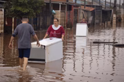 Cliciane de Souza da Silva e o marido Diorgenes Gonçalves Menezes carregam uma geladeira pela rua da cidade de Sapucaia do Sul