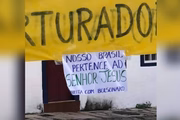 Cartaz colado à faixa relaciona ato à direita e ao movimento pró-Bolsonaro