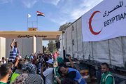 Voluntários egípcios comemoram quando os primeiros caminhões que transportam ajuda para a Faixa de Gaza cruzam a passagem de fronteira de Rafah, entre o Egito e a Faixa de Gaza