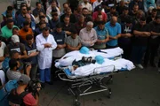 Amigos e parentes lamentam as mortes dos jornalistas palestinos Muhammad Sobh e Saeed Al-Taweel, que foram mortos durante ataques aéreos israelenses