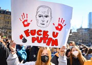 Em manifestação em Hessen, Alemanha, pessoas levantam cartazes em reúpido à Rússia. Em um deles, está escrito "Fuck U Putin" 