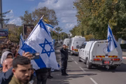 israelenses agitam a bandeira nacional e se reúnem ao longo da estrada enquanto o comboio de veículos transportando os corpos da familia Bibas entregues pelo Hamas, chega ao Centro Nacional de Medicina Forense em Tel Aviv