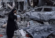 Uma mulher caminha pelos escombros de prédios em Gaza