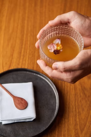 Em seguida o chá de porco chega à mesa com um caldo feito de legumes, carne e osso de porco com pétalas de flores do Cerrado flutuando na superfície