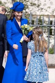Kate Middleton segura um buquê de flores enquanto conversa com a filha, a princesa Charlotte