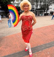 Salete Campari posa de vestido vermelho e leque de arco-íris 