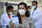 Vacinada mostra documento com o imunizante da Pfizer