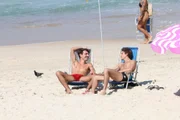 Jesuíta Barbosa, acompanhado do namorado, de sunga vermelha