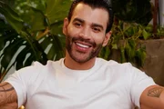 Gusttavo Lima posa sorridente e de blusa branca para as redes sociais