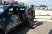 Policial militar observa movimento em praia do litoral paulista durante patrulhamento da Operação Verão