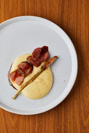 Na sequência a picanha de porco é servida na cama de aligot de mandioca acompanhado de aspargos com bacon