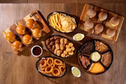 Também há uma petisqueira recheada de farofa de bacon, bacon em tiras, molho cheddar, cebola caramelizada, cebola crispy e maionese especial de alho
